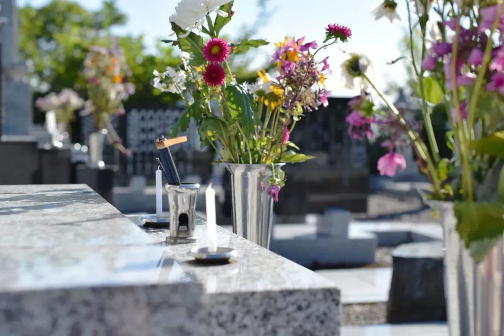 Bouquets de fleurs fraîches colorées posés sur une tombe en marbre poli.
